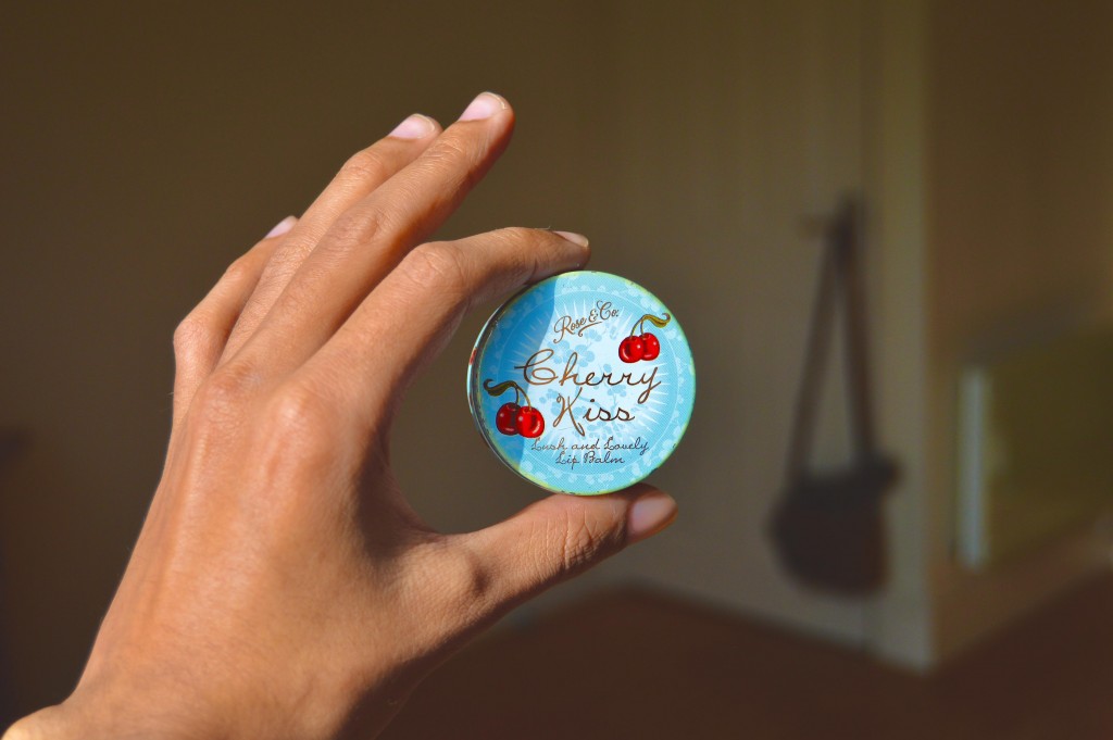 A hand holding a lip balm to illustrate how lipstick brands are surviving in the coronavirus
