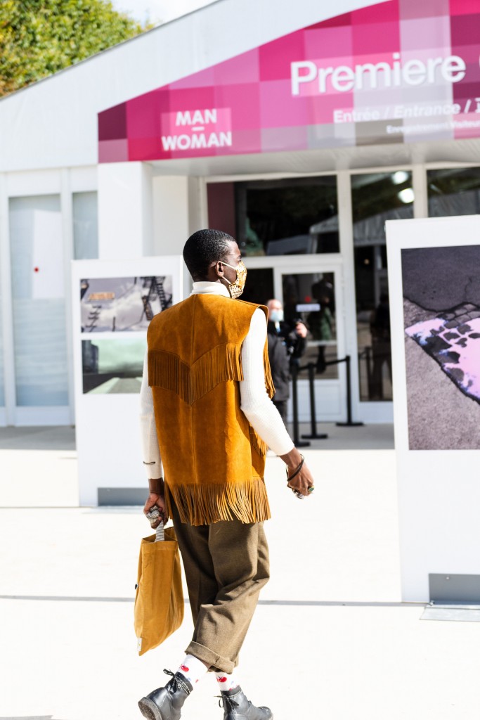 An African man dressed fashionably walking to a store