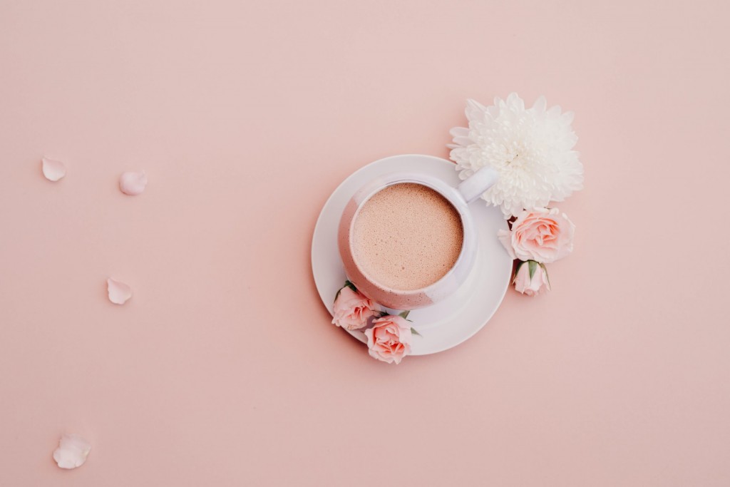 A cup of pink tea against a pink background