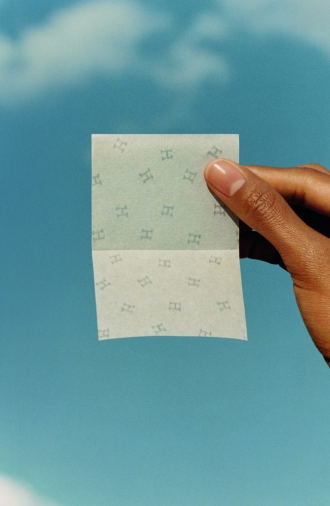 A hand holds up the Hermes Plein Air blotting paper