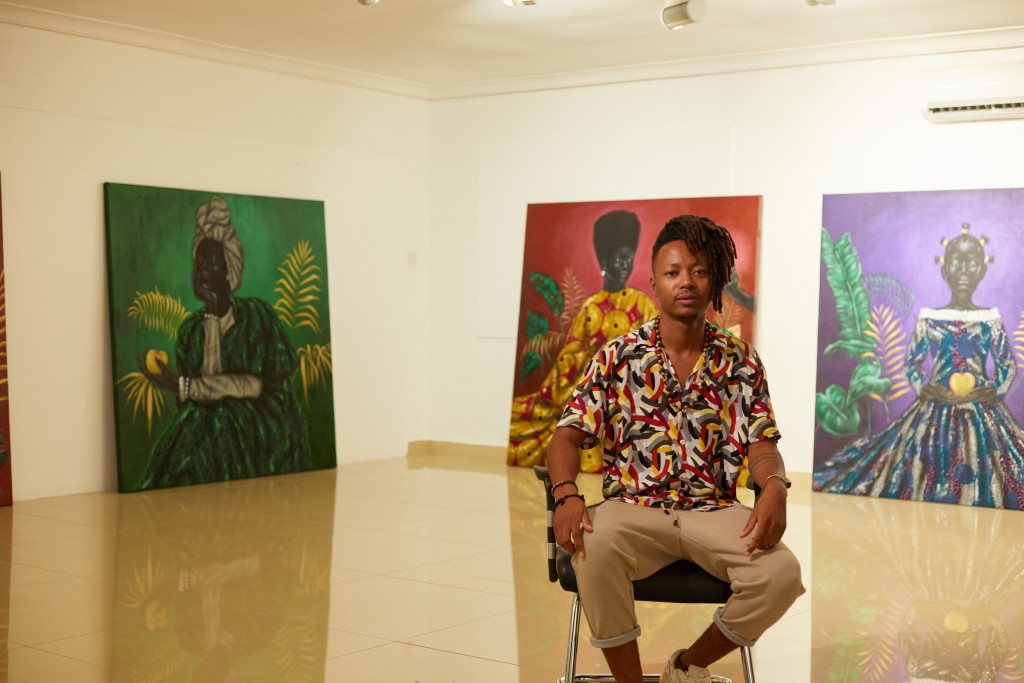 Reggie Khumalo sits in front of the paintings that form the Mental Revolution collection