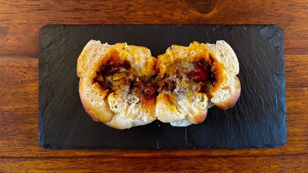 The bread bun split open to reveal the ewa agoyin inside