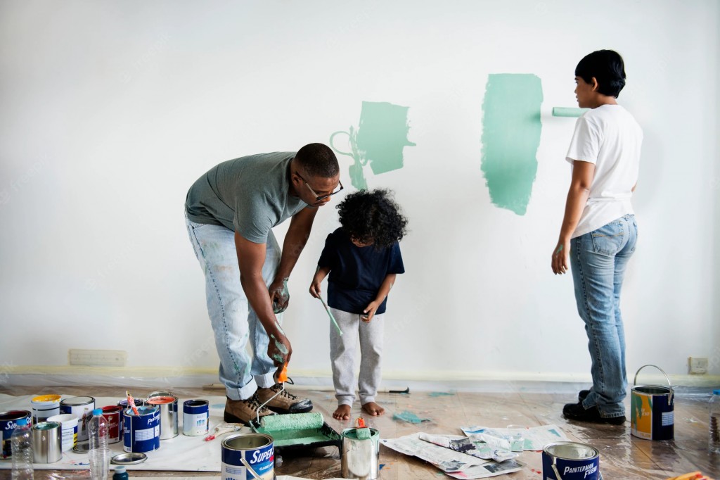 a black african-american family painting a wall