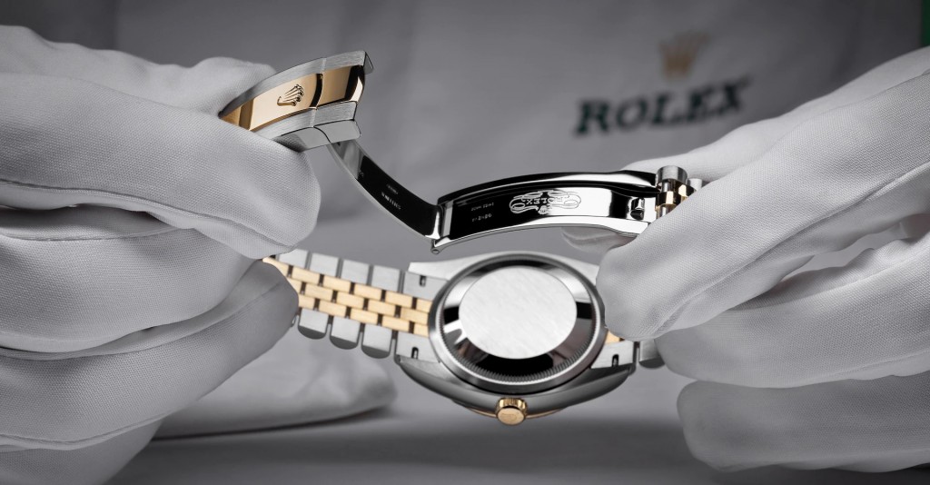 A hand holding a Rolex watch