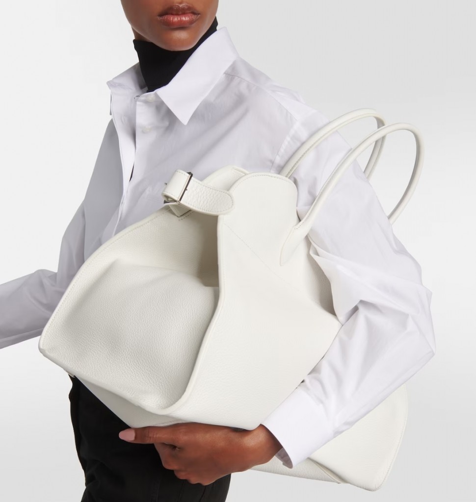 A model carrying the Row's Margaux tote in white